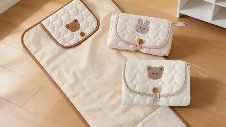 Trocadores de fraldas portáteis acolchoados em tons de bege com estampas de ursinho e coelho